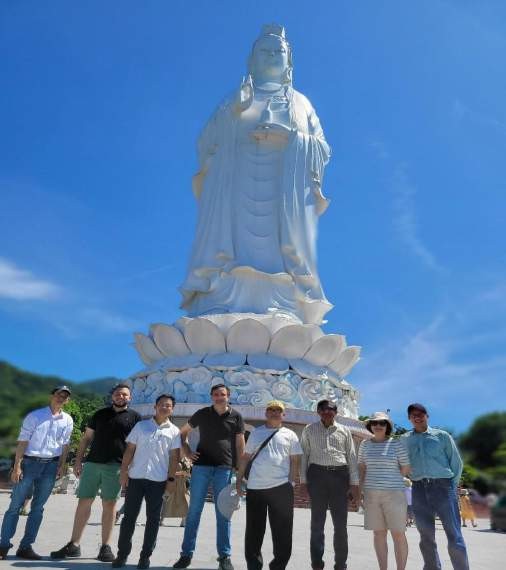 A group of people standing in front of a large statue AI-generated content may be incorrect.