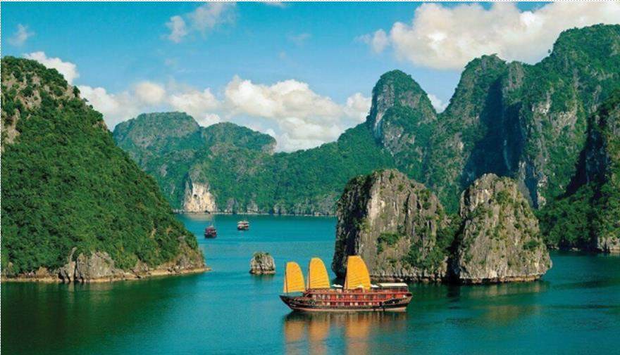 A boat in the water with mountains in the background with Ha Long Bay in the background AI-generated content may be incorrect.