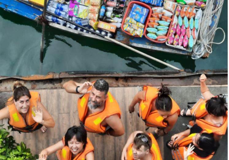A group of people in orange vests standing on a dock AI-generated content may be incorrect.