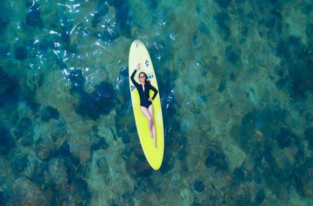 A person lying on a surfboard in the water AI-generated content may be incorrect.