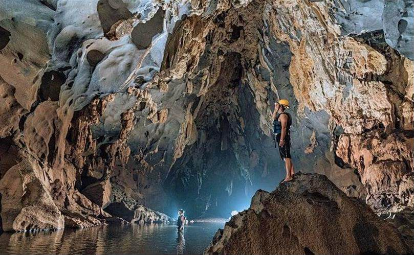 A person standing on a rock in a cave AI-generated content may be incorrect.